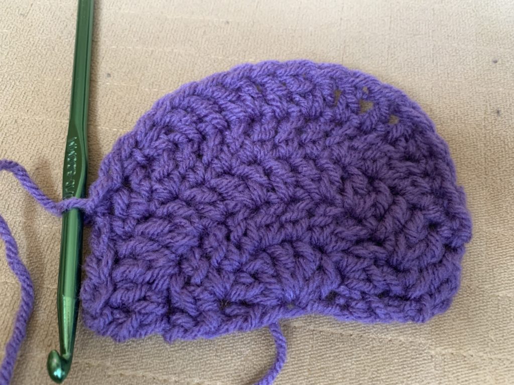 Semi circular rows worked flat in purple yarn