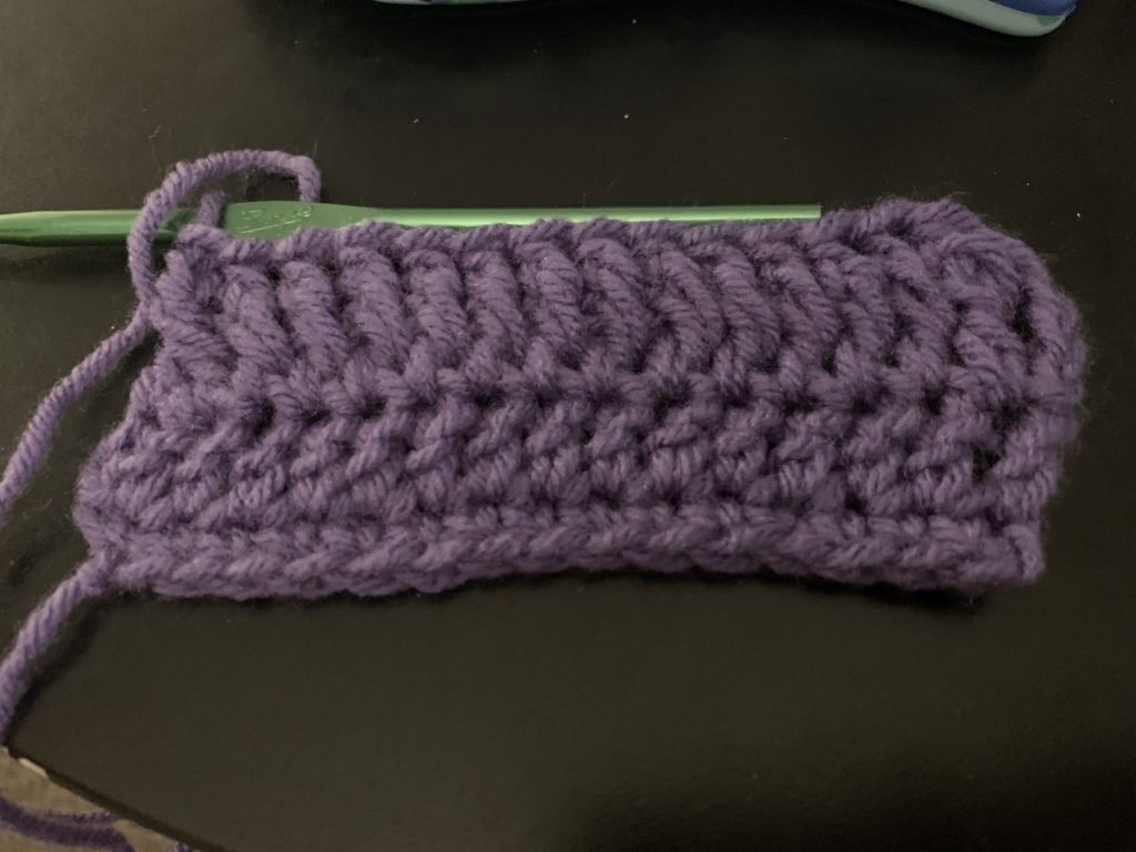 several rows of crochet worked in purple yarn, of different heights